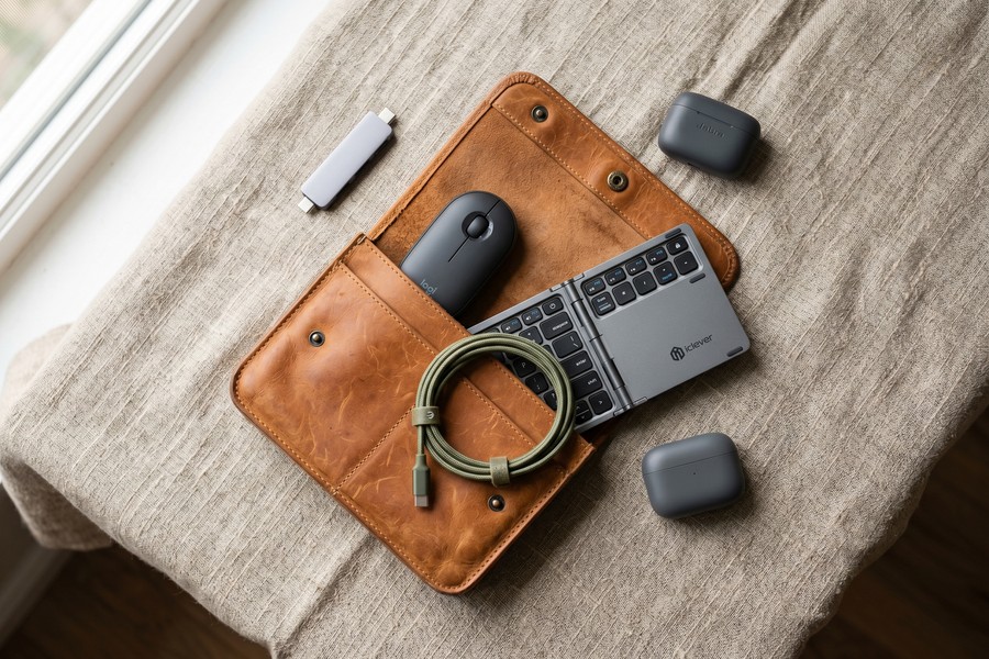 Digital nomad compact hardware kit laid out on a wooden cafe table