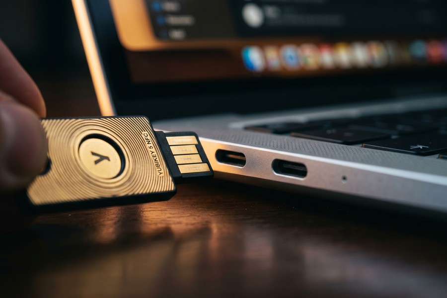 A YubiKey hardware security key inserted into a laptop USB port for authentication
